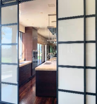 Large Metal and Glass Barn Doors Between Kitchen and Dining Room
